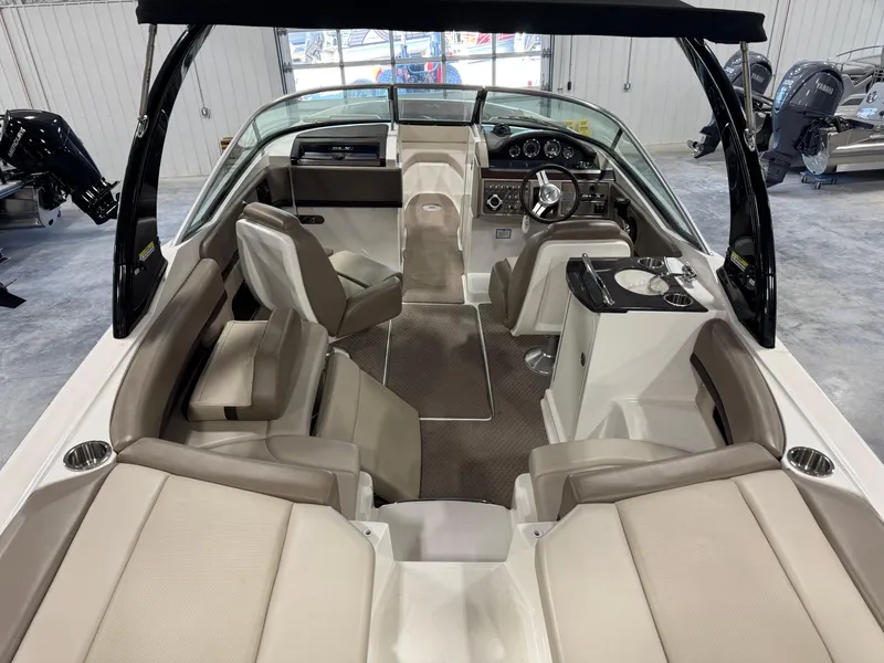 Slide: The Image of 2011 Sea Ray 250 SLX boat interior with beige seating and modern dashboard. - 5