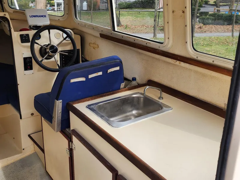 Slide: The Image of 2006 C-Dory 22 Cruiser interior with steering wheel and kitchenette sink. - 11
