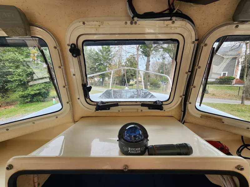 Slide: The Image of Interior view of a 2006 C-Dory 22 Cruiser boat with compass and windows. - 14