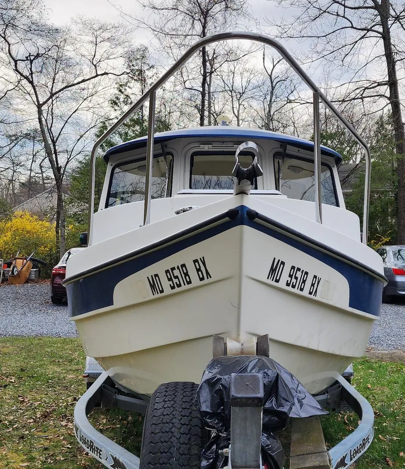 Slide: The Image of 2006 C-Dory 22 Cruiser boat on trailer, parked outdoors with trees in the background. - 3