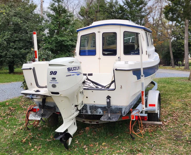 Slide: The Image of 2006 C-Dory 22 Cruiser on trailer with Suzuki 90 outboard motor, parked on grass. - 5