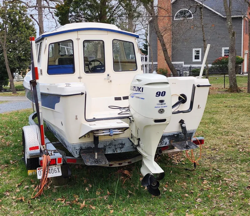 Slide: The Image of 2006 C-Dory 22 Cruiser with Suzuki 90 outboard motor on trailer, parked on grass. - 6