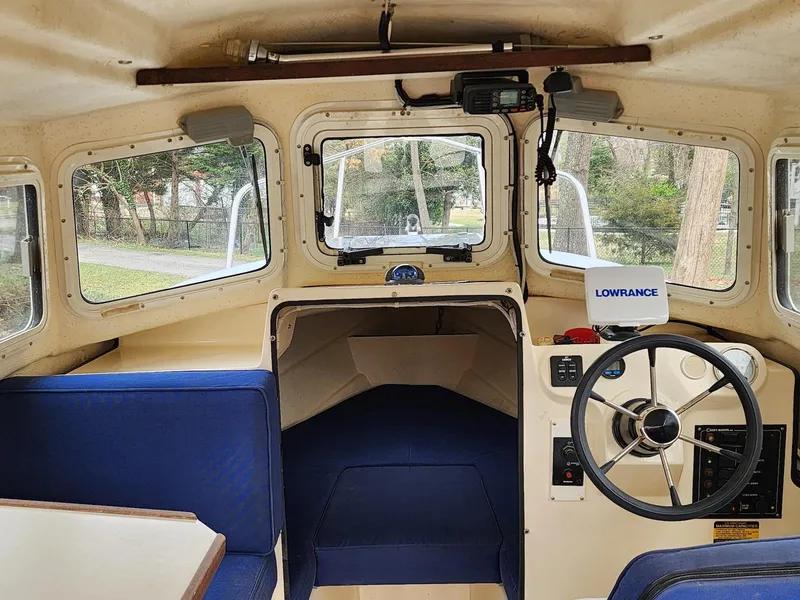Slide: The Image of Interior of a 2006 C-Dory 22 Cruiser boat with steering wheel and seating. - 9