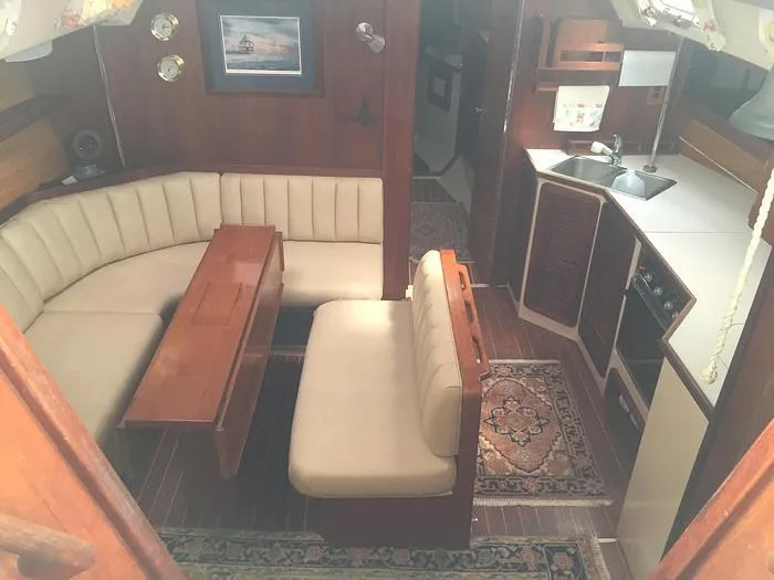 Slide: The Image of Interior of 1989 Catalina 42 MkII sailboat with cozy seating and compact kitchen area. - 11