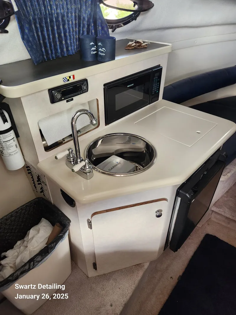 Slide: The Image of 1997 Regal 258 Commodore boat interior with kitchenette, sink, and microwave. - 11
