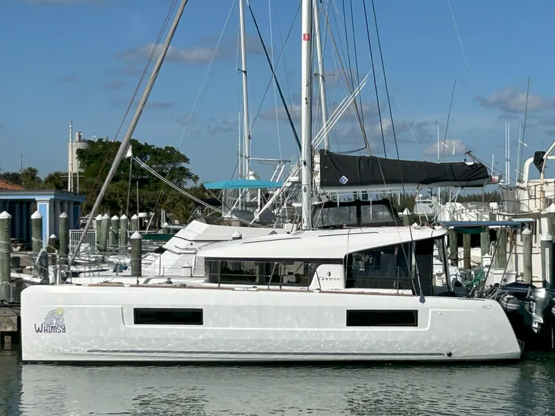 Slide: The Image of 2020 Lagoon 40 catamaran docked at a marina, featuring sleek design and modern amenities. - 0
