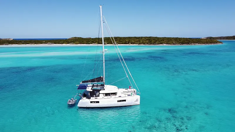 Slide: The Image of 2020 Lagoon 40 catamaran sailing in clear turquoise waters near a tropical island. - 1