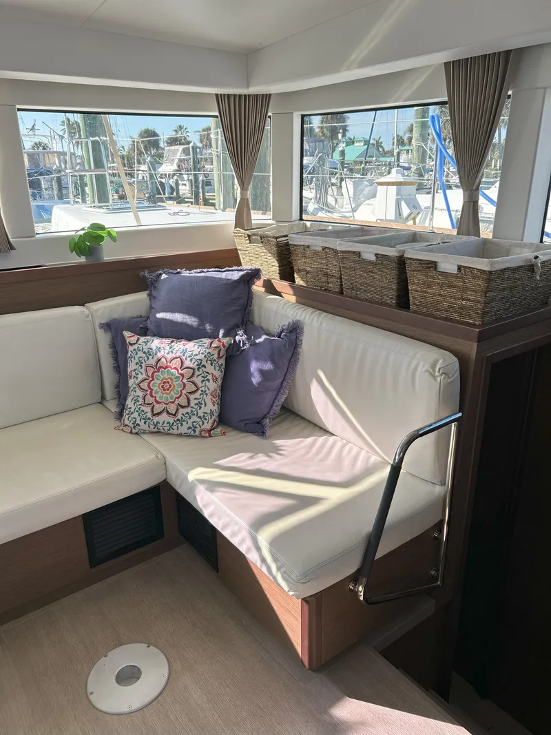 Slide: The Image of Interior of 2020 Lagoon 40 catamaran with cozy seating and decorative pillows. - 15