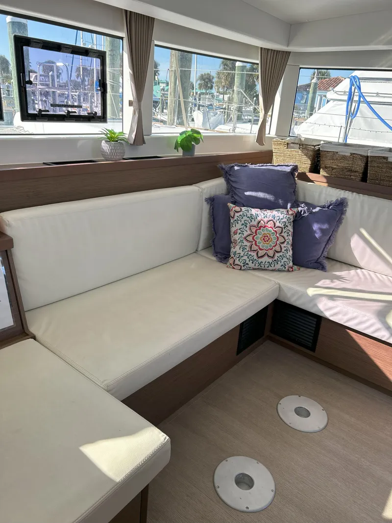 Slide: The Image of Interior of 2020 Lagoon 40 catamaran with white seating and decorative pillows. - 16