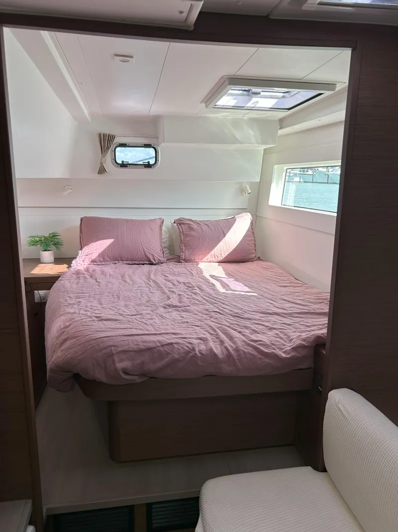 Slide: The Image of Interior of 2020 Lagoon 40 catamaran cabin with cozy bed and natural light. - 20