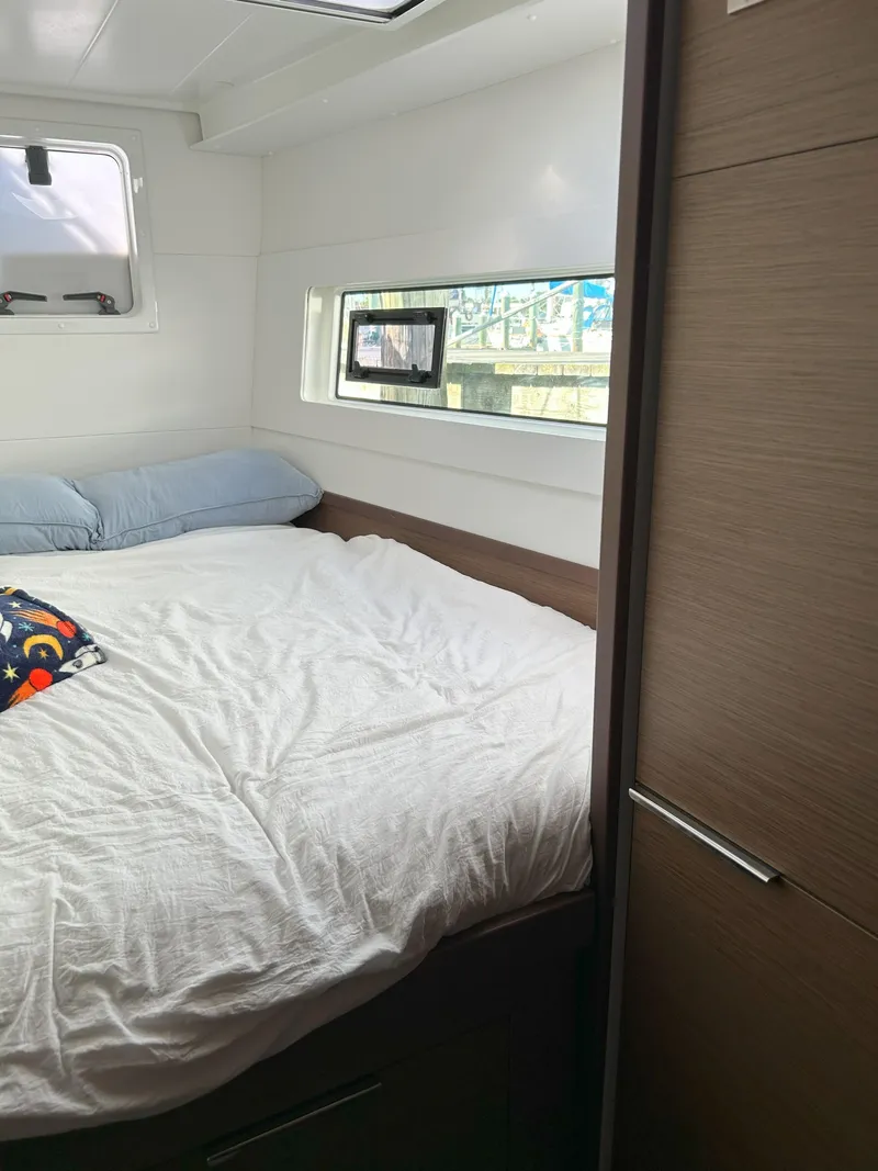 Slide: The Image of 2020 Lagoon 40 yacht cabin with bed, window, and modern interior design. - 21