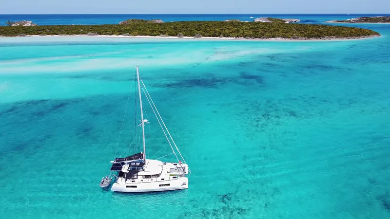 Slide: The Image of 2020 Lagoon 40 catamaran sailing in turquoise waters near a tropical island. - 30