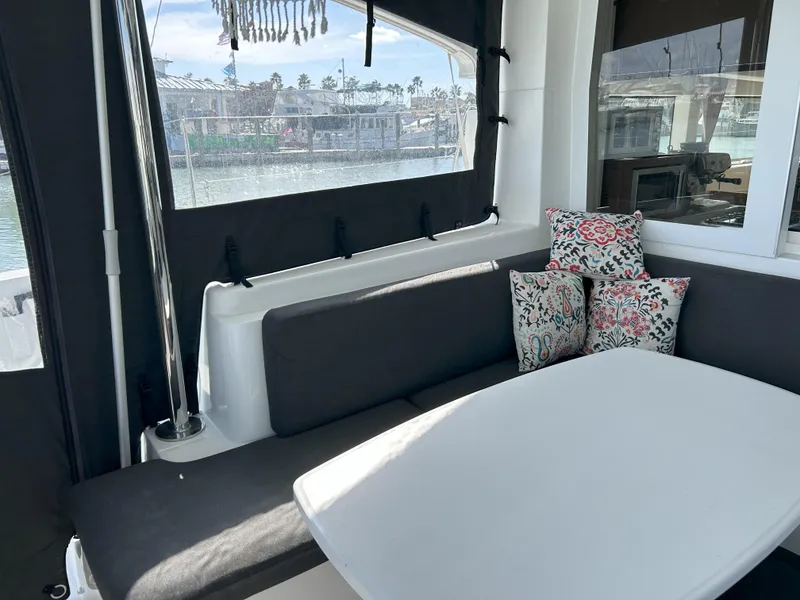 Slide: The Image of Cozy seating area on 2020 Lagoon 40 catamaran with cushions and table. - 6