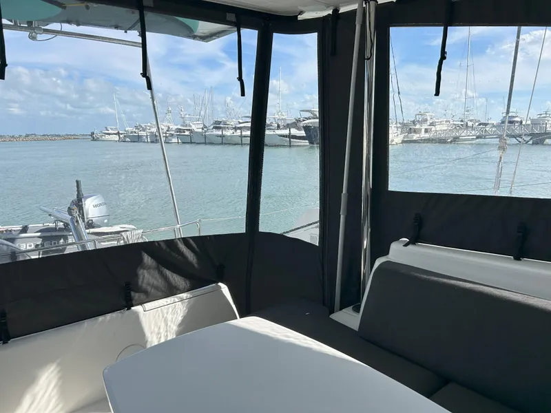 Slide: The Image of 2020 Lagoon 40 catamaran interior with marina view, featuring seating and table. - 7