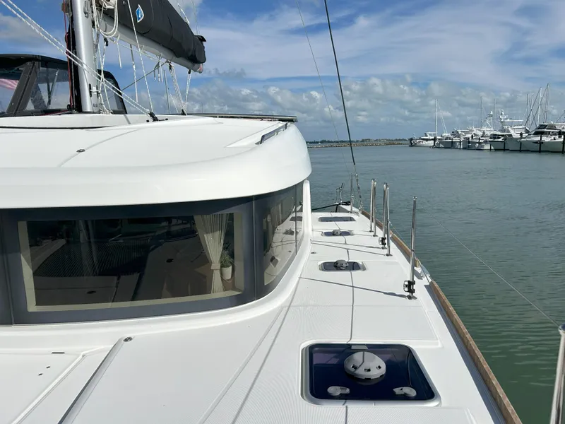 Slide: The Image of 2020 Lagoon 40 catamaran docked in a marina under a clear blue sky. - 8