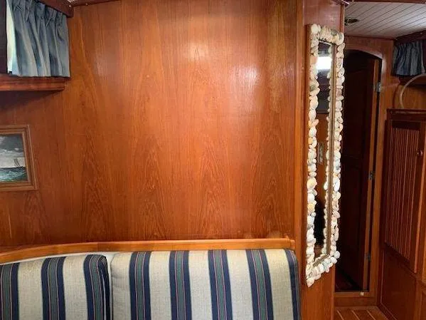 Slide: The Image of Interior of 1989 Custom SEA MAID with wood paneling, striped seating, and shell-framed mirror. - 12