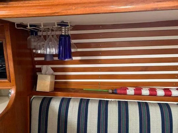 Slide: The Image of Interior of 1989 Custom SEA MAID boat with striped seating, glass rack, and umbrella. - 13