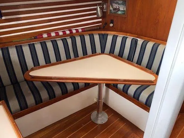 Slide: The Image of Cozy 1989 Custom SEA MAID boat interior with striped seating and triangular table. - 4