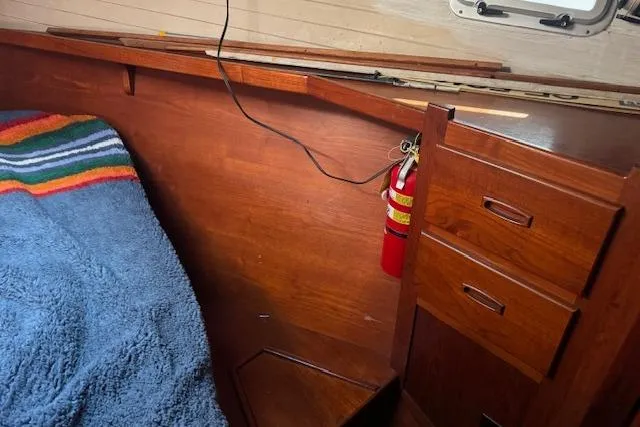 Slide: The Image of Interior of 1989 Custom SEA MAID boat with wooden cabinetry and colorful blanket. - 50