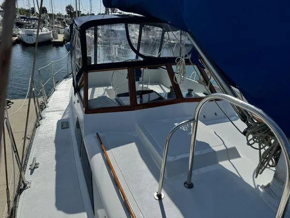 Slide: The Image of 1989 Custom SEA MAID sailboat docked at marina, featuring a sleek deck and blue canopy. - 1