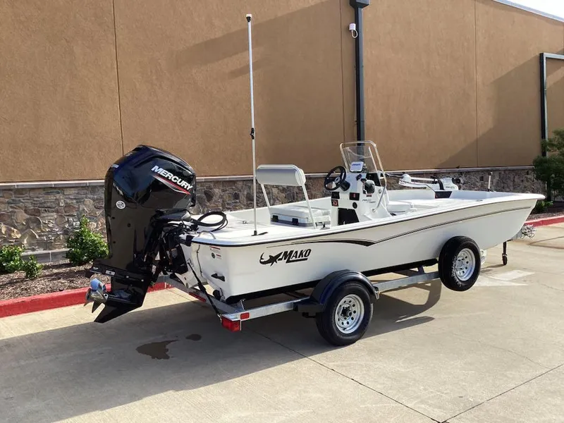 Slide: The Image of 2025 Mako Pro Skiff 17 CC boat with Mercury engine on trailer, parked outdoors. - 4