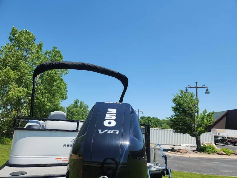 Slide: The Image of 2024 Regency 250 DL3 boat with powerful engine, parked outdoors under clear blue sky. - 11