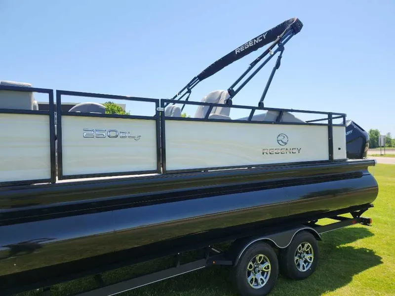 Slide: The Image of 2024 Regency 250 DL3 pontoon boat on trailer, side view, sunny day. - 13