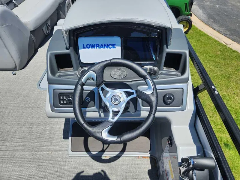 Slide: The Image of 2024 Regency 250 DL3 boat dashboard with Lowrance display and steering wheel. - 16