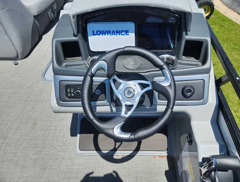 Slide: The Image of 2024 Regency 250 DL3 boat dashboard with steering wheel and Lowrance display. - 6