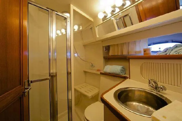 Slide: The Image of Bathroom interior of 1994 Carver 390 yacht with shower, sink, and mirror lighting. - 8