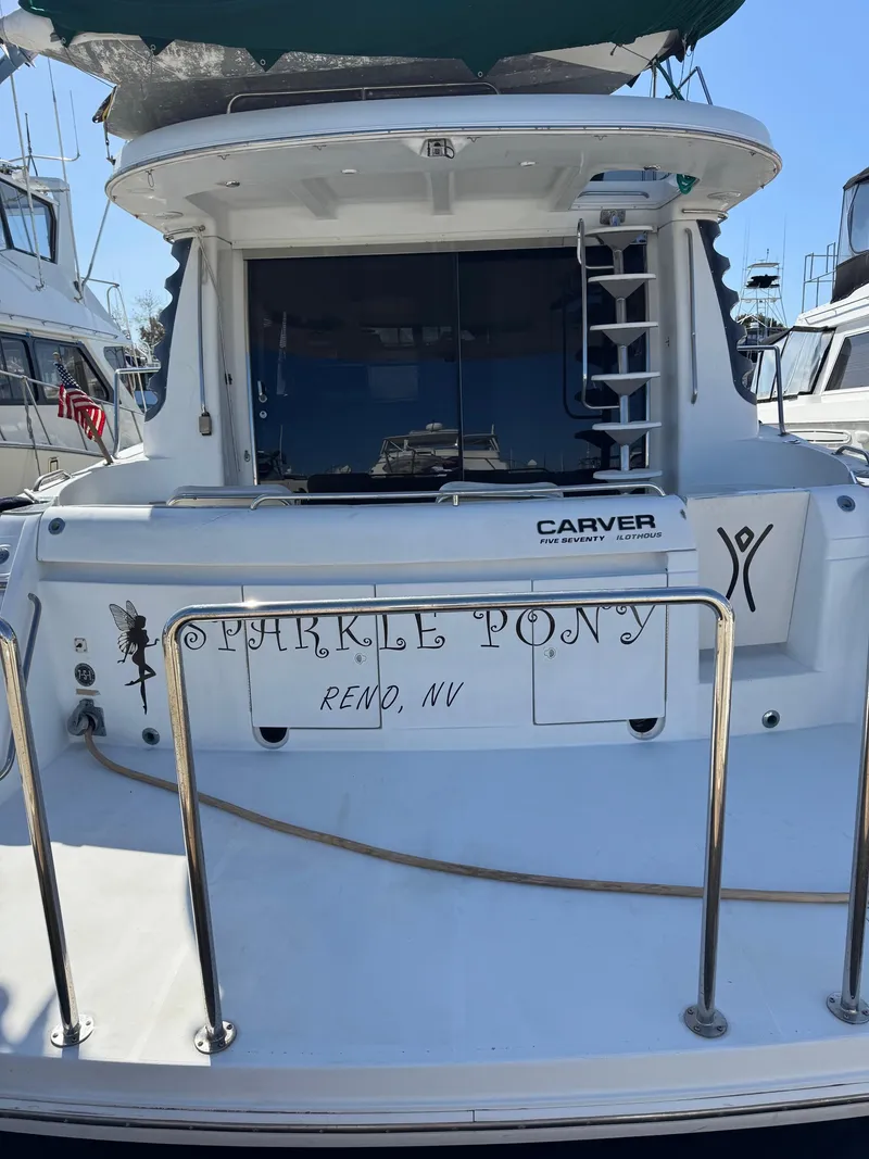 Slide: The Image of 2002 Carver 570 Voyager Pilothouse yacht docked, rear view with "Sparkle Pony" name. - 10