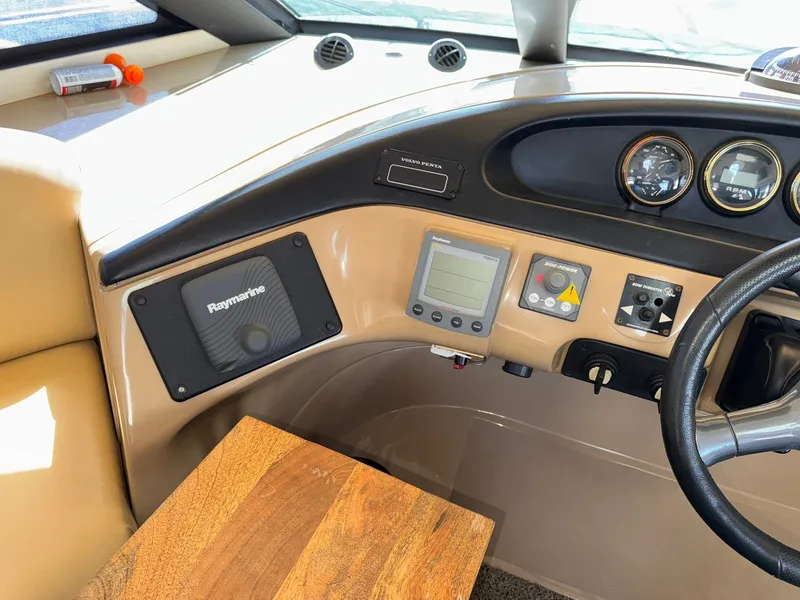 Slide: The Image of 2002 Carver 570 Voyager Pilothouse helm with Raymarine equipment and wooden accents. - 19