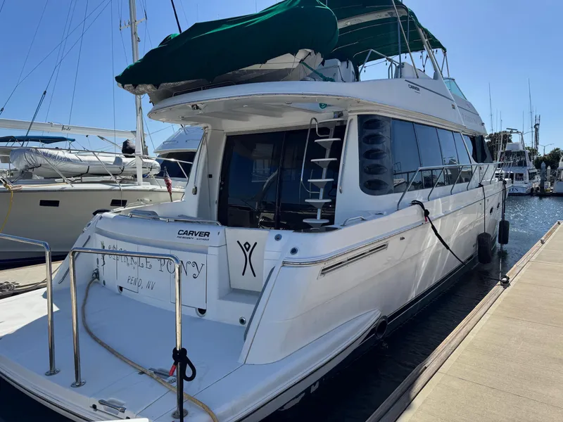 Slide: The Image of 2002 Carver 570 Voyager Pilothouse yacht docked at marina, rear view. - 2