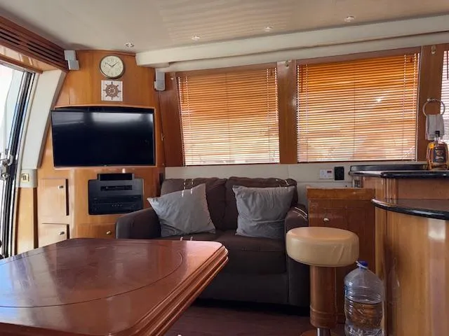 Slide: The Image of Luxurious interior of 2002 Carver 570 Voyager Pilothouse with sofa, TV, and wooden accents. - 23