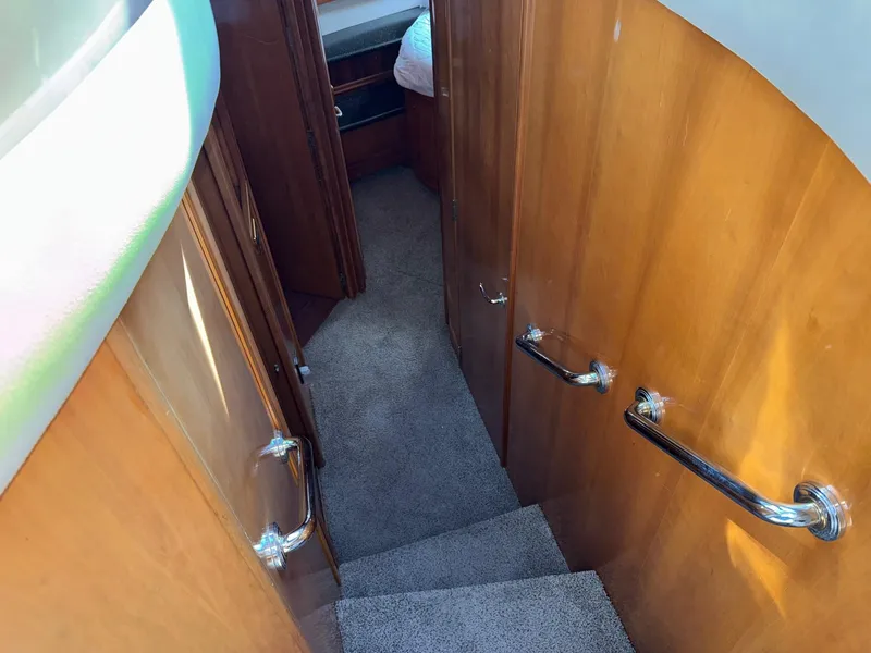 Slide: The Image of Staircase inside 2002 Carver 570 Voyager Pilothouse with wooden walls and carpeted steps. - 25