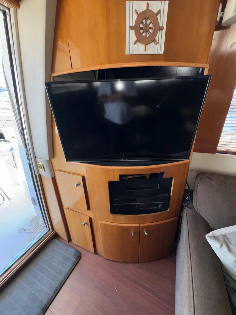 Slide: The Image of Interior of 2002 Carver 570 Voyager Pilothouse with TV and wooden cabinetry. - 26