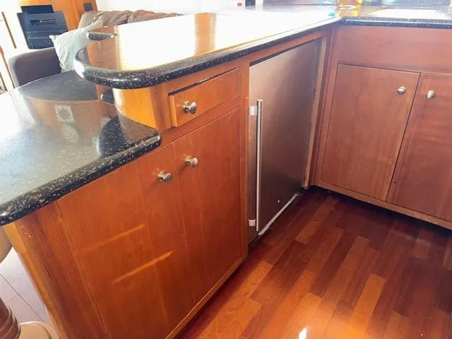 Slide: The Image of Wooden cabinetry and black countertop in 2002 Carver 570 Voyager Pilothouse kitchen area. - 27