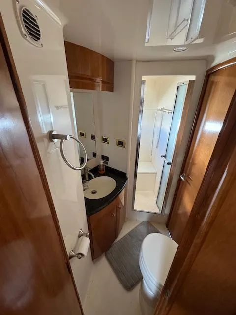 Slide: The Image of 2002 Carver 570 Voyager Pilothouse bathroom with wood accents and modern fixtures. - 33
