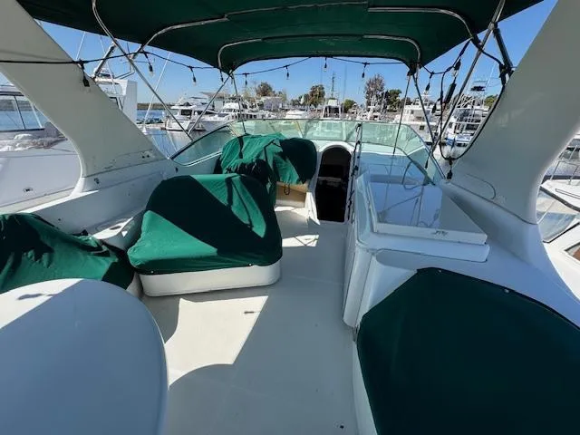 Slide: The Image of 2002 Carver 570 Voyager Pilothouse with green canopy and seating, docked at marina. - 38