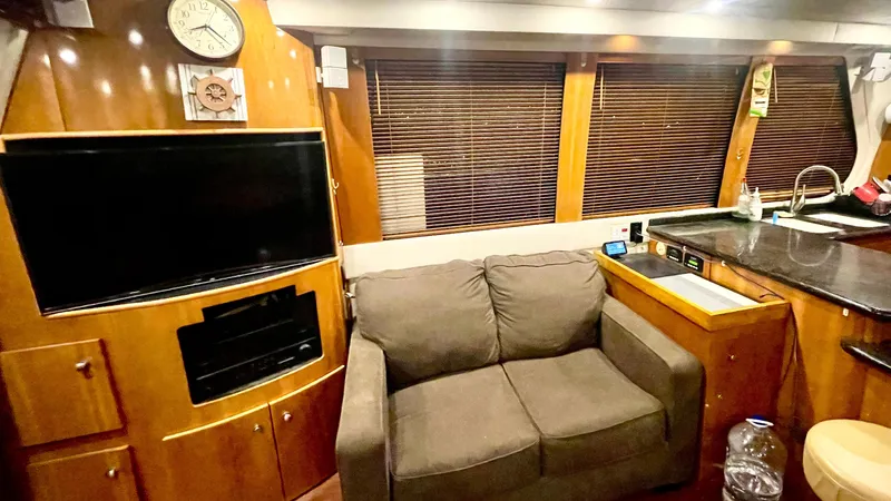 Slide: The Image of Luxurious interior of 2002 Carver 570 Voyager Pilothouse with sofa, TV, and wooden accents. - 17