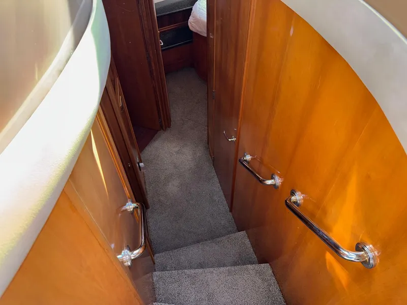 Slide: The Image of Staircase inside 2002 Carver 570 Voyager Pilothouse with wooden paneling and carpeted steps. - 24