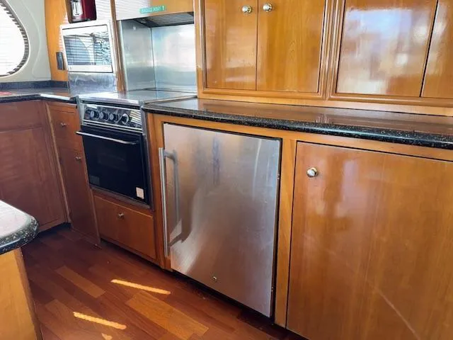 Slide: The Image of Kitchen area of 2002 Carver 570 Voyager Pilothouse with wood cabinets and stainless steel appliances. - 28