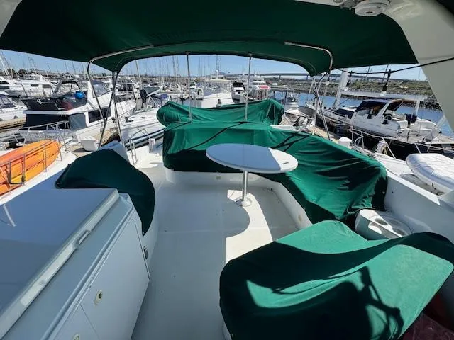 Slide: The Image of 2002 Carver 570 Voyager Pilothouse yacht with green canopy and seating, docked at marina. - 37