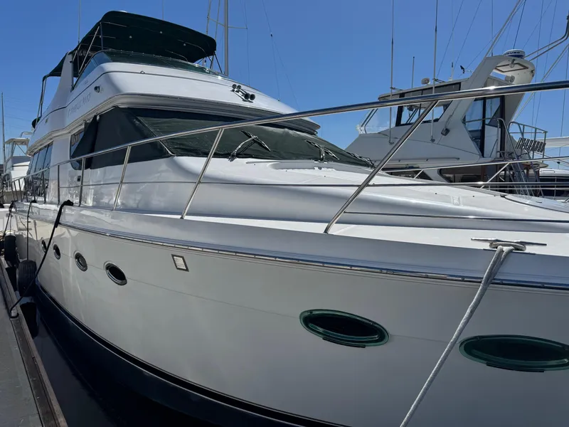 Slide: The Image of 2002 Carver 570 Voyager Pilothouse yacht docked at marina under clear blue sky. - 46