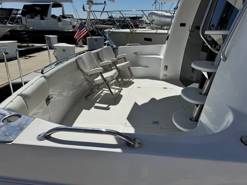 Slide: The Image of 2002 Carver 570 Voyager Pilothouse yacht deck with chairs and spiral staircase. - 48