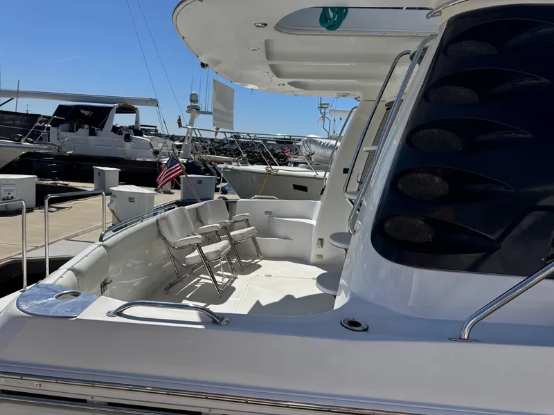 Slide: The Image of 2002 Carver 570 Voyager Pilothouse yacht docked, featuring spacious deck and seating area. - 49