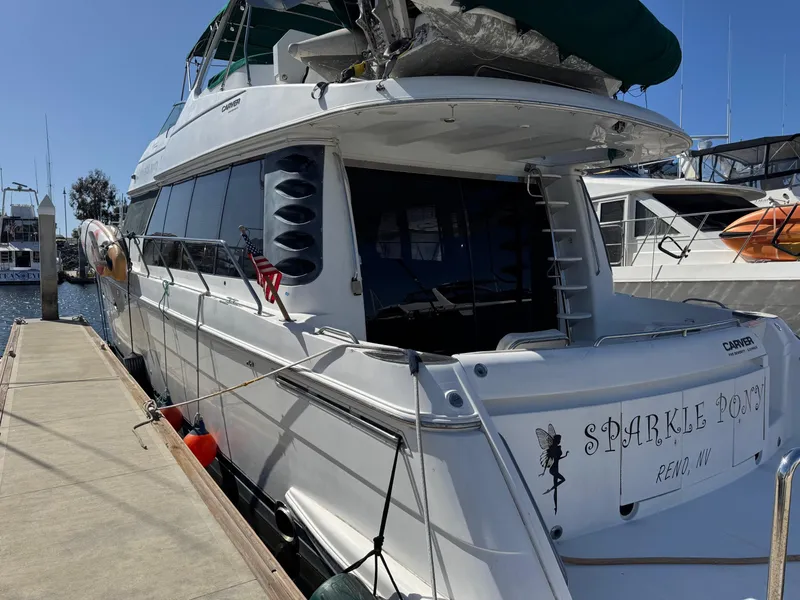 Slide: The Image of 2002 Carver 570 Voyager Pilothouse yacht docked, named "Sparkle Pony," with visible ladder and flag. - 7