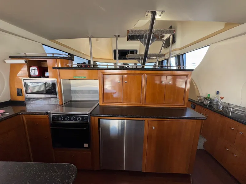 Slide: The Image of Interior of 2002 Carver 570 Voyager Pilothouse kitchen with wood cabinetry and modern appliances. - 8