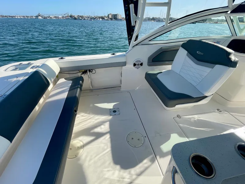 Slide: The Image of 2021 Robalo 247 Dual Console boat interior with seating, on a sunny day by the water. - 10