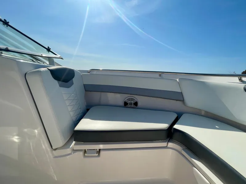 Slide: The Image of 2021 Robalo 247 Dual Console boat interior seating under clear blue sky. - 13